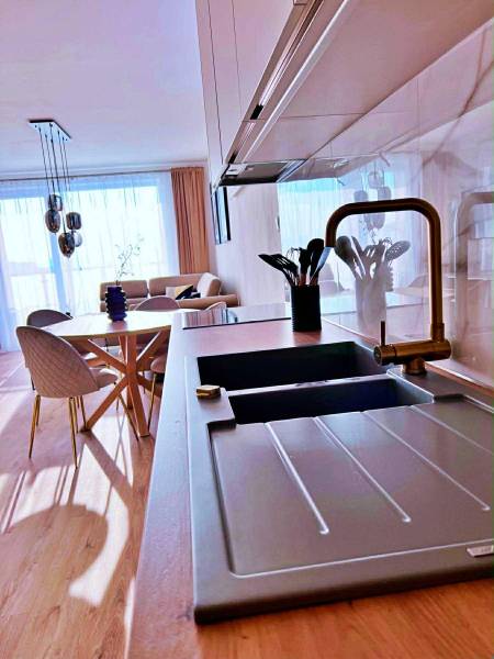 Konyha egy 3 szobás lakásban világos padlóval, fa dekorral és stílusos ülőgarnitúrával.