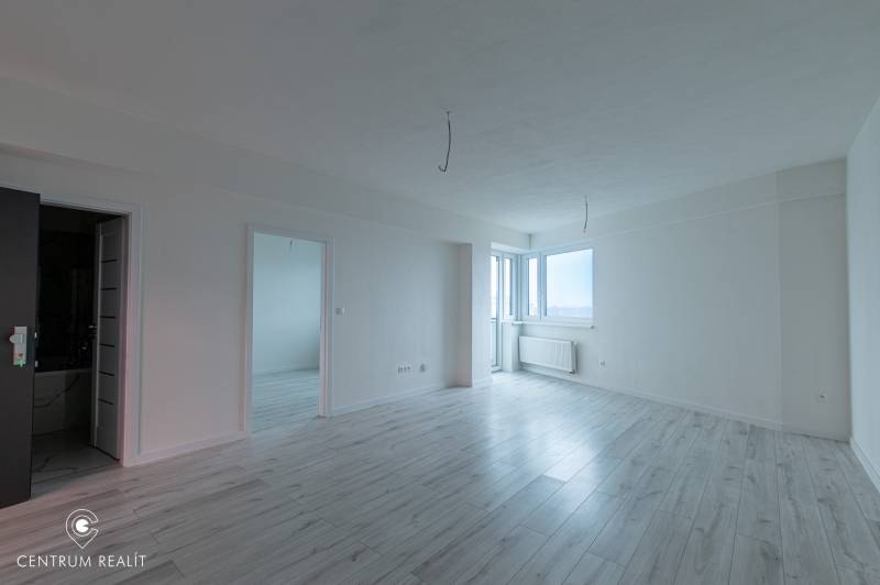 Világos belső tér fa mintázatú padlóval egy kétszobás lakásban.