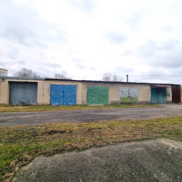 Épület színes garázskapukkal Kuklovban, aszfaltút mellett.