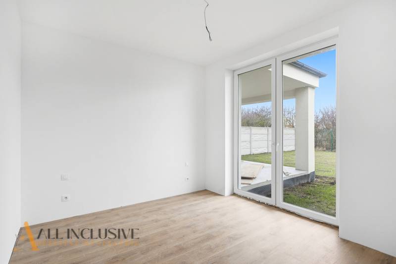 Szoba egy családi házban nagy ablakkal és fa dekorációjú padlóval.