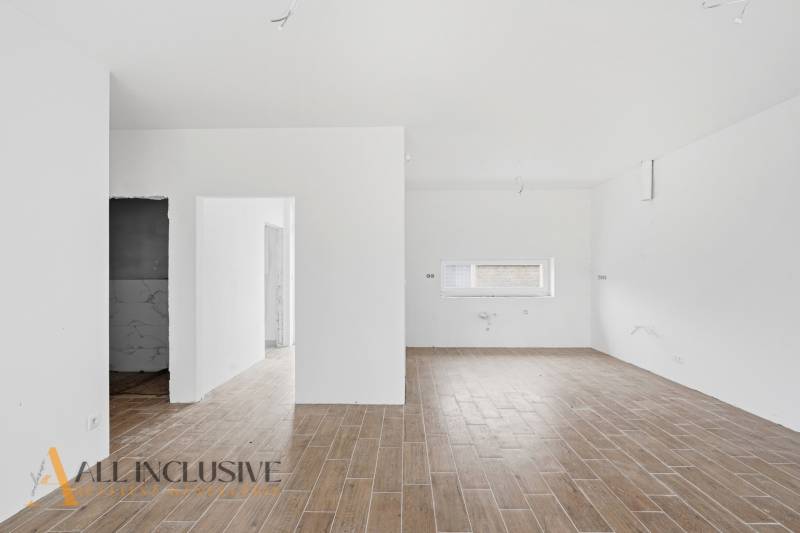 Családi ház belső tere fa dekorációjú padlóval és fehér falakkal.