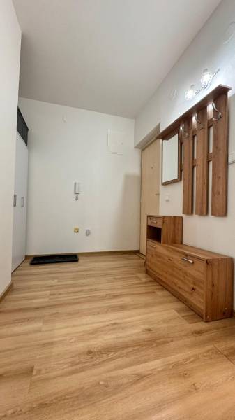 Előszoba egy kétszobás lakásban fa dekorációjú padlóval és fa bútorokkal.