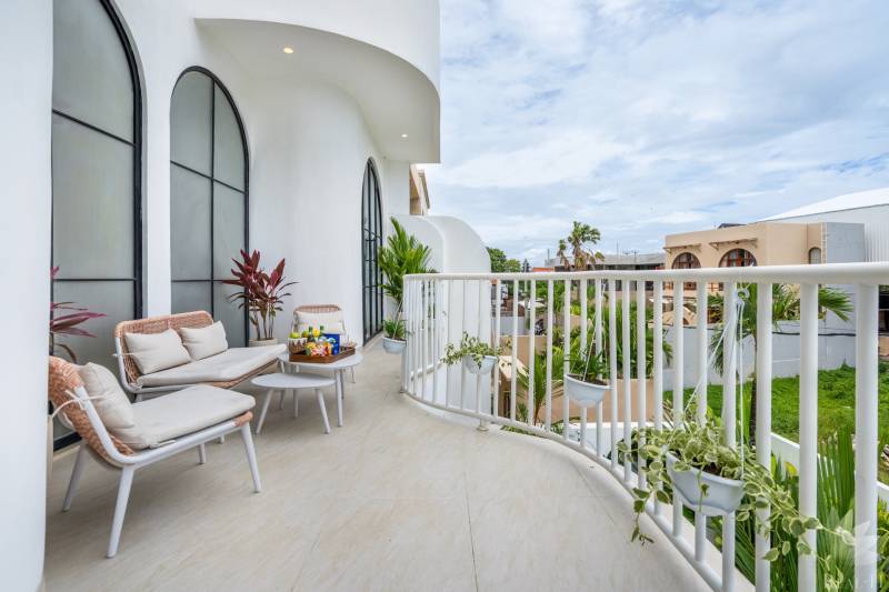 Tágas erkély a villában kényelmes ülőhellyel, növényekkel és kilátással Berawára Cangguban.