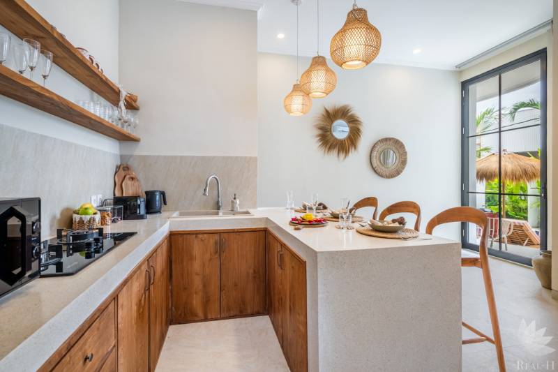 Egy villa belső tere konyhasarokkal, fa szekrényekkel és dekoratív tükrökkel.