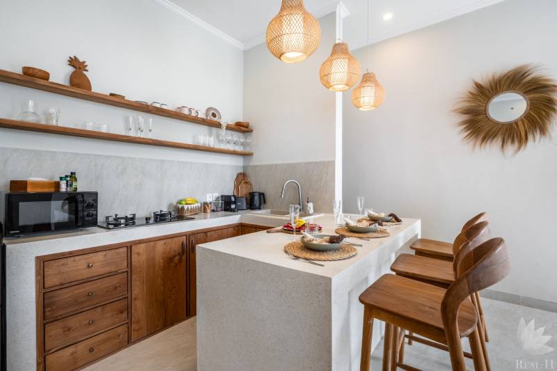 Villa konyhája stílusos fa elemekkel, bárszékekkel és függőlámpákkal.