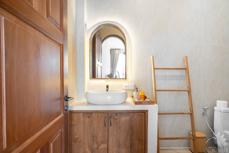 Fürdőszoba a villában tükörrel, mosdóval és dekorációként létrával.