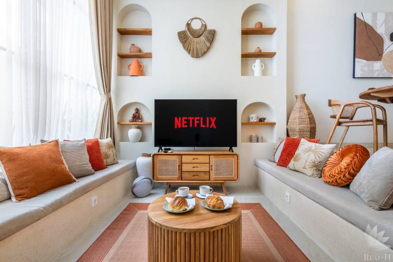 Kényelmes nappali a villában, televízióval, párnákkal és dekorációkkal, kávét szolgálnak fel.