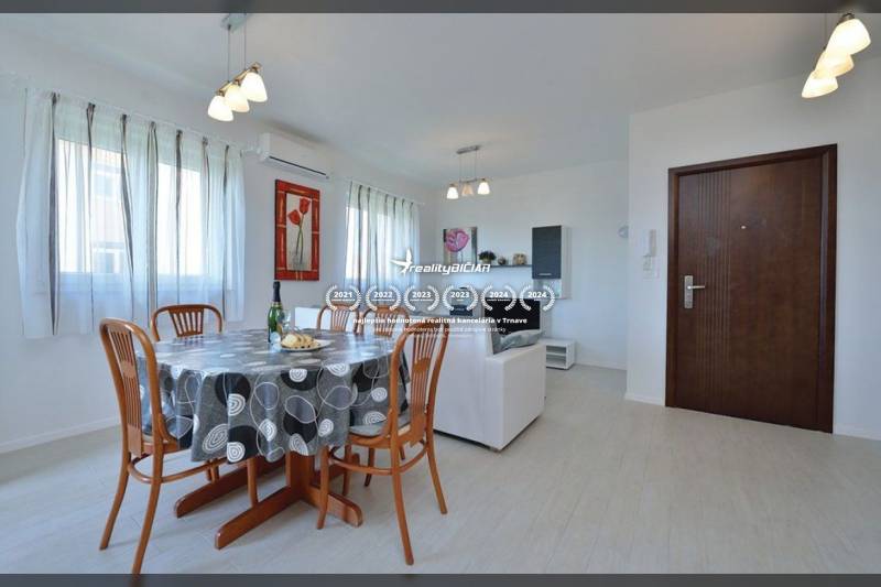 Étkezőasztal székekkel egy kétszobás lakásban, világos helyiség, fa dekoros padló.