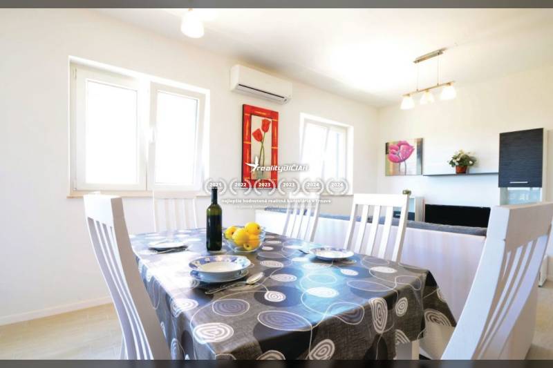 Étkező sarok egy kétszobás lakásban, megterített asztallal és faldekorációkkal.