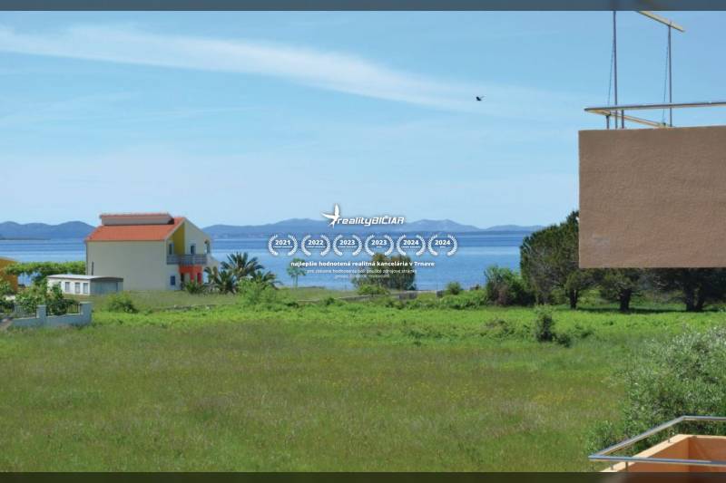 Kilátás egy 2 szobás lakásból Privlakán, a Privlakán, tengerrel és zölddel a háttérben.