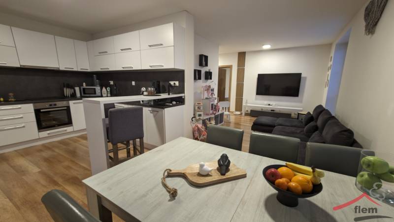 Konyha nappalival egy kétszobás lakásban, világos konyhabútor, fa mintázatú padló.