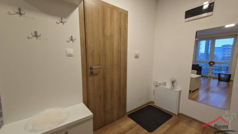 Bejárati folyosó egy kétszobás lakásban, fa dekoros padlóval és praktikus fogasokkal.