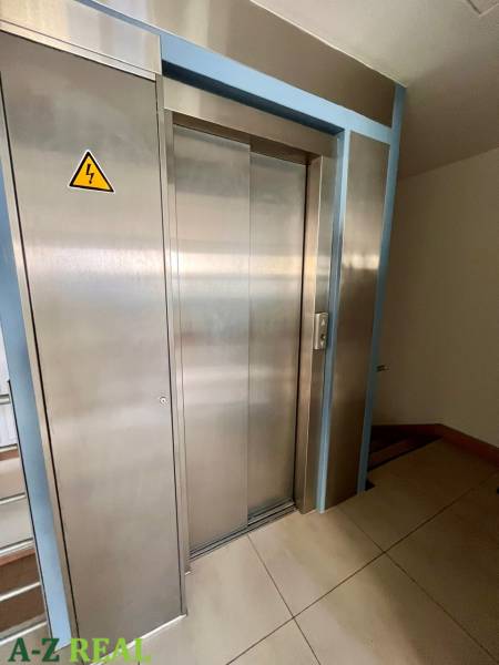 Rozsdamentes acél lift irodákban, padlón csempével.