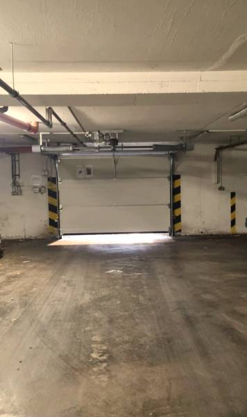 Garázs épület betonpadlóval és garázskapukkal.