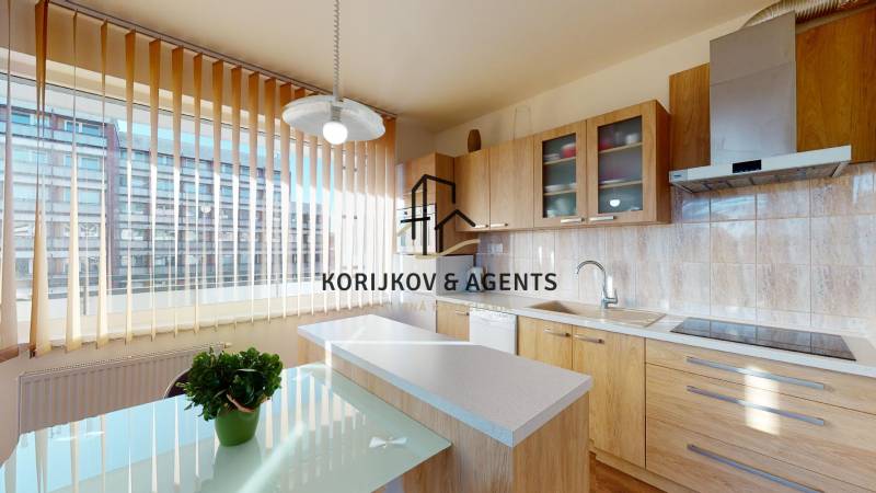 Konyha fa mintázatú padlóval egy kétszobás lakásban, világos berendezés és nagy ablak.