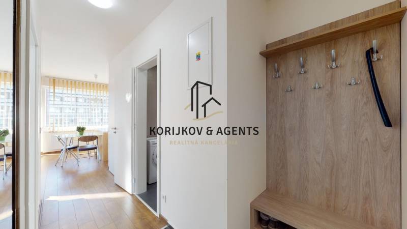 Folyosó fa mintázatú padlóval és fogassal egy kétszobás lakásban.