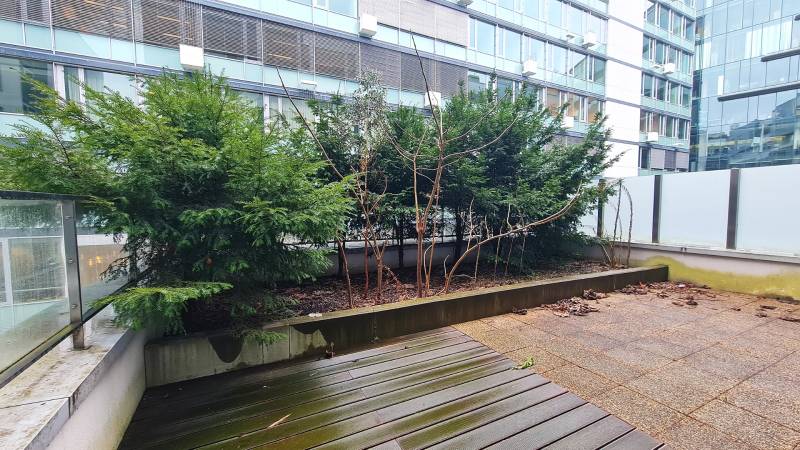 Terasz növényekkel, fa dekorációjú padlóval a pozsonyi Dvořák rakparton.