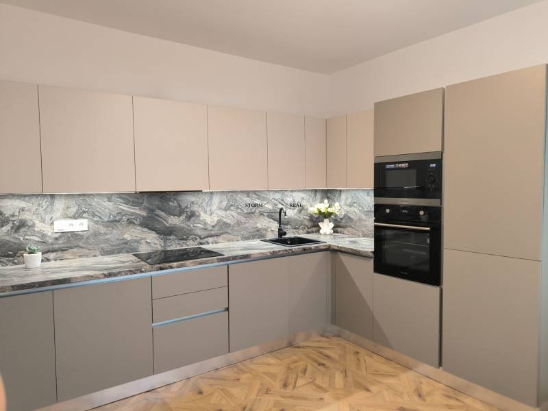 Konyha egy 4 szobás lakásban márvány munkalappal és fa dekor padlóval.