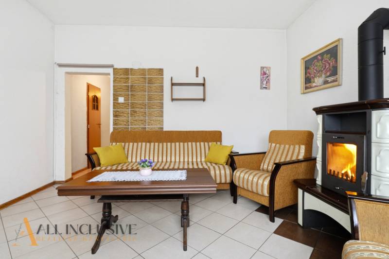 Nappali egy családi házban kandallóval, csíkos kanapéval és dohányzóasztallal.