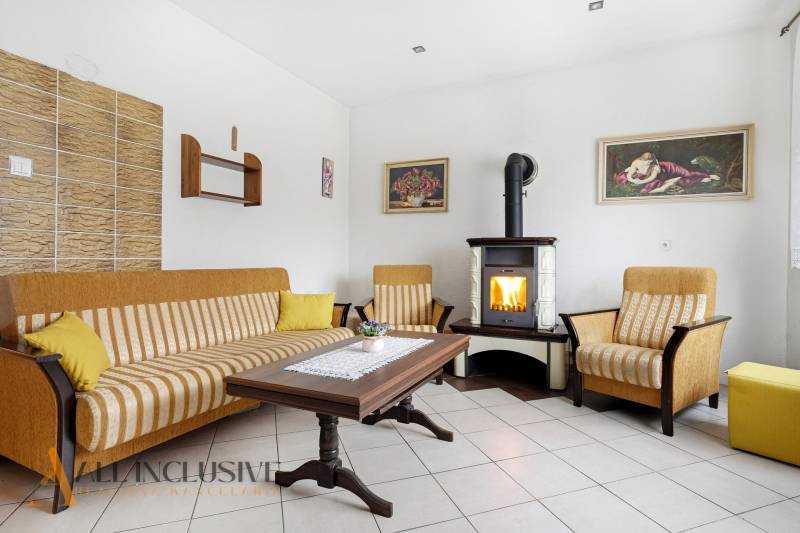 Nappali egy családi házban kandallóval, kanapéval és faasztallal.