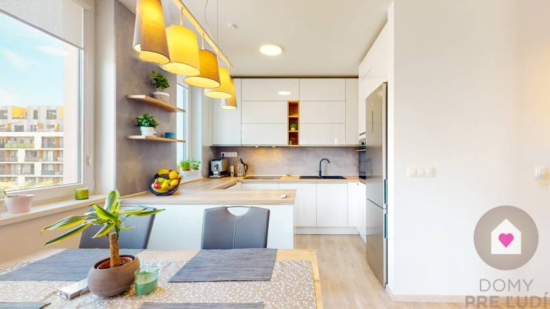 Konyha egy háromszobás lakásban, fa dekor padlóval, világítótestekkel és szobanövényekkel.