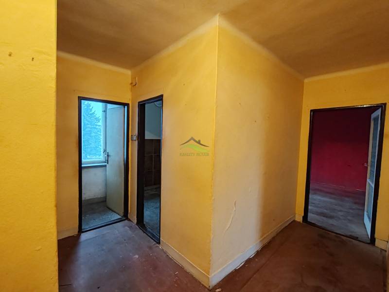 Folyosó három szobával egy kétszobás lakásban, fa dekor padlóval.