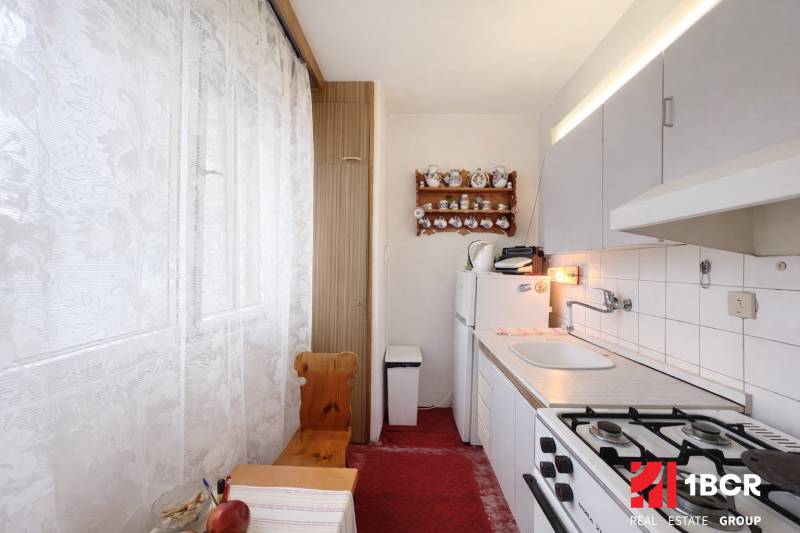 Hangulatos konyha gáztűzhellyel és rusztikus dekorációval egy egyszobás lakásban.