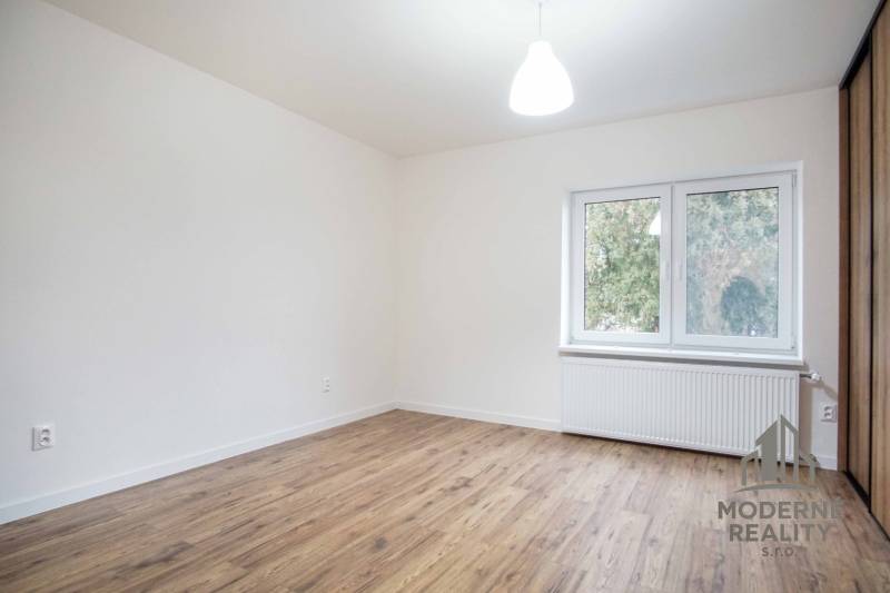 Szoba egy családi házban elektromos aljzatokkal és fa dekor padlóval.