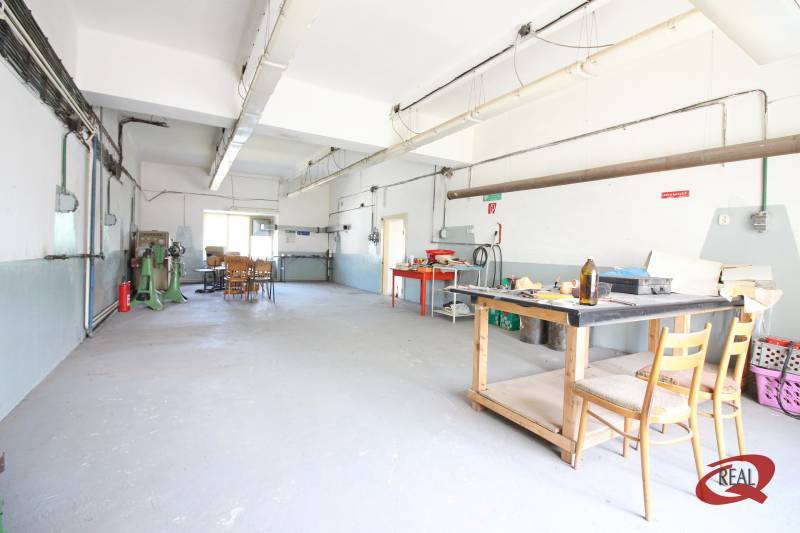 Ipari belső tér épületben, munkaasztallal és székekkel.