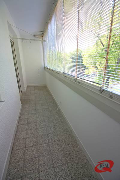 Üvegezett lodzsa terrakotta padlóval, árnyékolókkal és kilátással, amely alkalmas egy 3 szobás lakás számára.