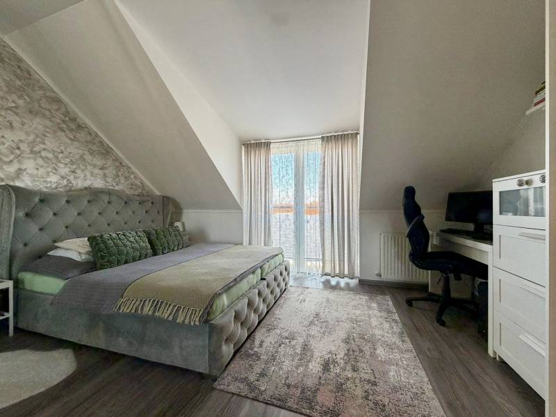 Hálószoba egy kétszobás lakásban franciaággyal, íróasztallal és fa dekorációjú padlóval.