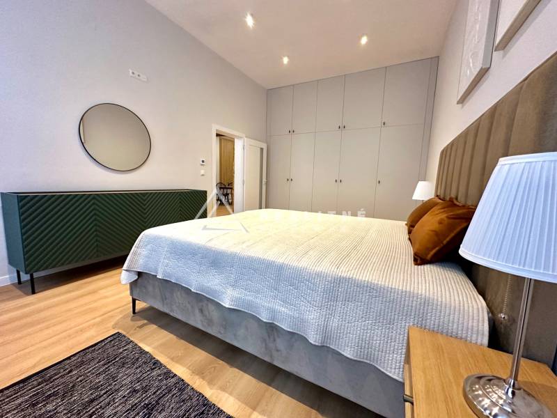 Hálószoba egy kétszobás lakásban ággyal, szekrényekkel és fa dekorációjú padlóval.