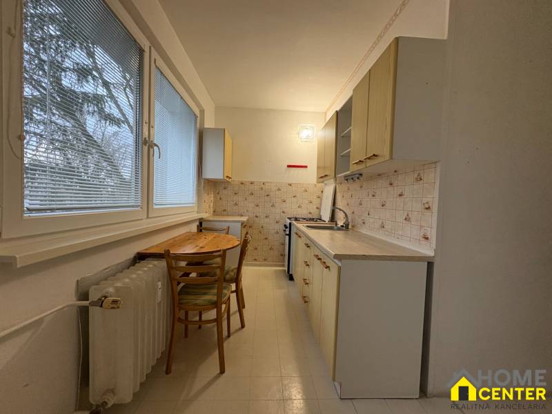 A háromszobás lakás konyhája egyszerű berendezéssel és kilátással rendelkező ablakokkal.