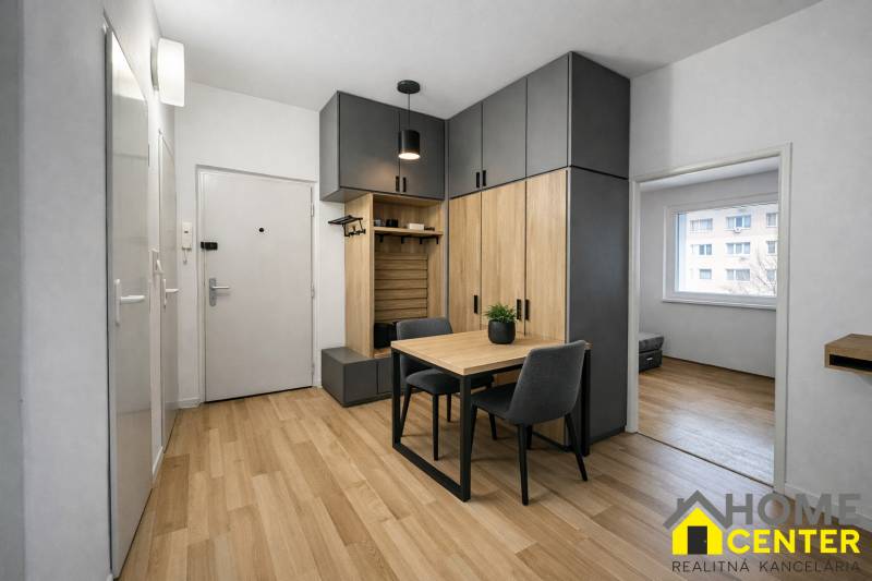 A háromszobás lakás előszobája fa dekor padlóval és beépített szekrényekkel.