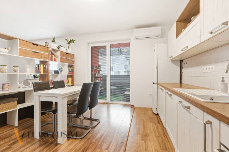 Konyha egy 2 szobás lakásban étkezőasztallal és fa dekorációjú padlóval.