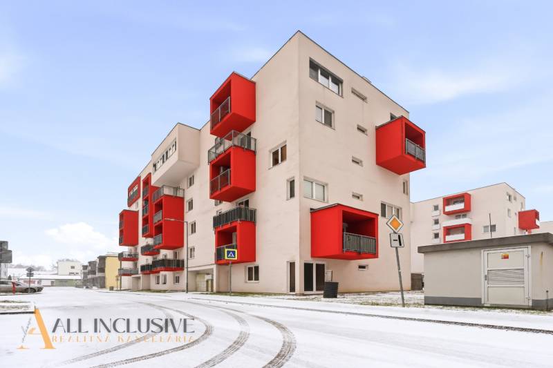 A vörös erkélyes lakóház külső része Vráble városában, ideális egy kétszobás lakás számára.