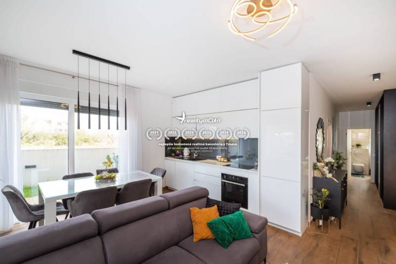 Nappali és konyha a nyaraló apartmanban fa hatású padlóval és étkező sarokkal.