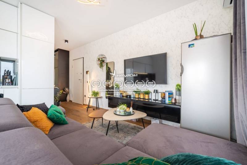 Stílusos nyaraló apartman belső tér kanapéval, asztallal és fa dekorációjú padlóval.