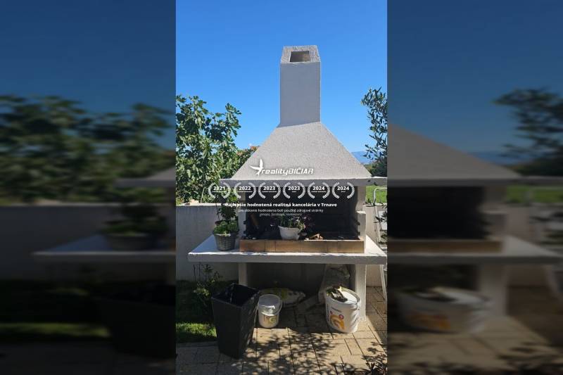 A Ninski Zatonban található nyaraló apartman külseje grillezővel és zöld növényzettel a teraszon.