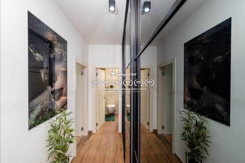 Folyosó egy üdülő apartmanban fa dekor padlóval, képekkel és tükrökkel.