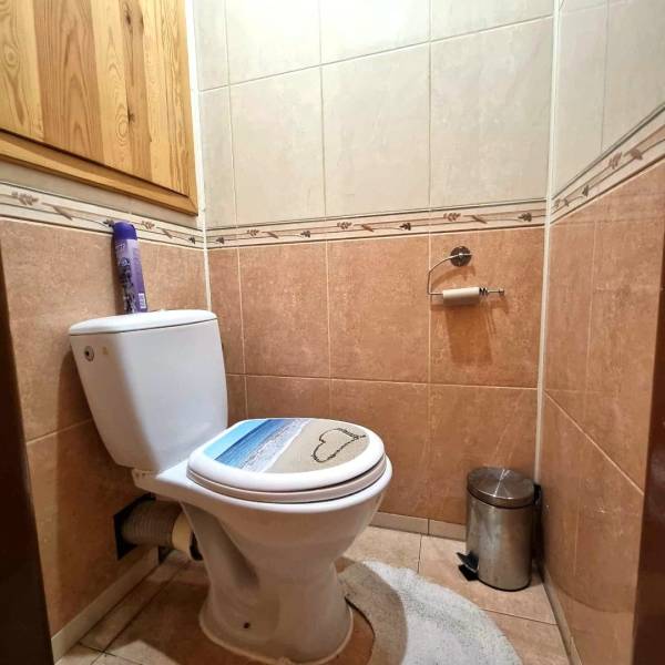 Fürdőszoba egy kétszobás lakásban kerámia burkolatokkal és WC-vel.