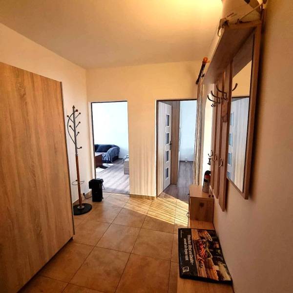 Folyosó egy 2 szobás lakásban fogassal és fa mintázatú padlóval.