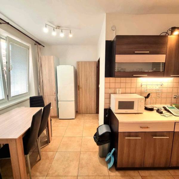 Konyha egy kétszobás lakásban étkezőasztallal és háztartási gépekkel.