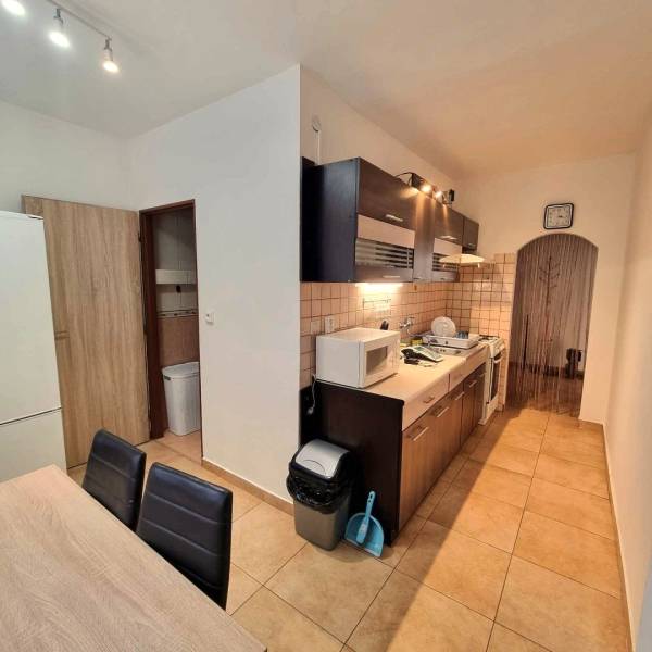 Konyha egy kétszobás lakásban csempével, fa dekorációval és berendezéssel.