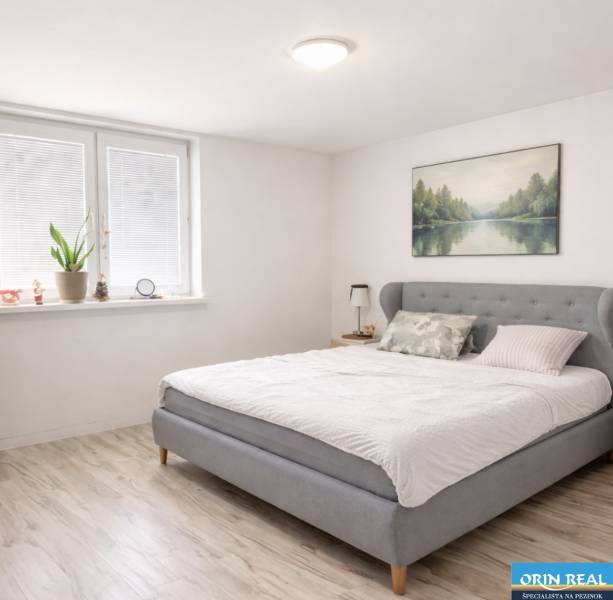 Világos hálószoba családi házban, franciaággyal és fa dekoros padlóval.