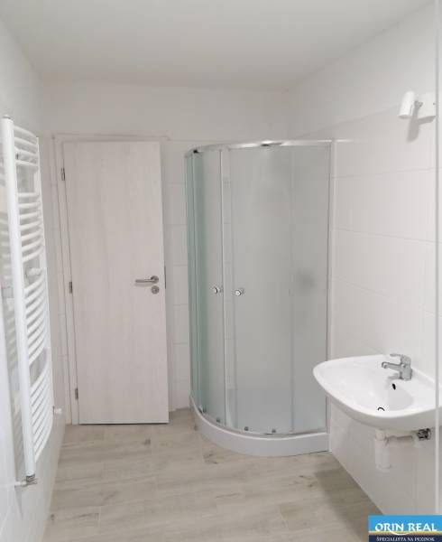 Fürdőszoba családi házban fehér zuhanyzóval és világos, fa mintázatú padlóval.