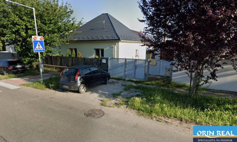 Családi ház a Bernolákovo-i Trnavská utcában, kapu előtt parkoló autóval.