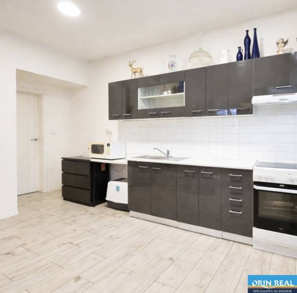 Konyha sötét szekrényekkel, fa dekoros padló, családi ház.