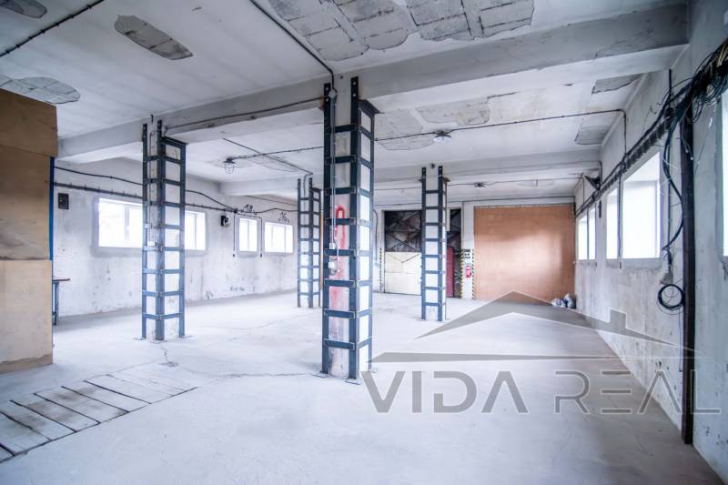 Ipari belső terek raktárakkal és csarnokokkal, betonfalakkal és vasgerendákkal.