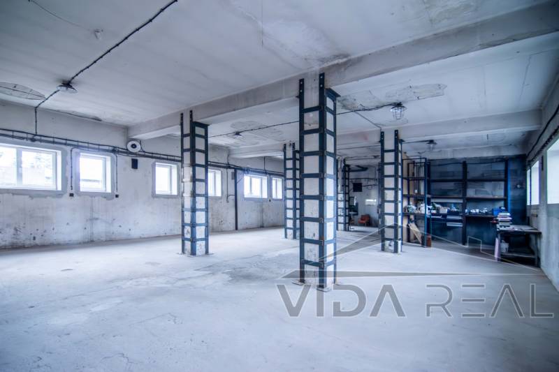 Oszlopokkal és ablakokkal rendelkező helyiségek, amelyeket raktárként és csarnokként használnak.
